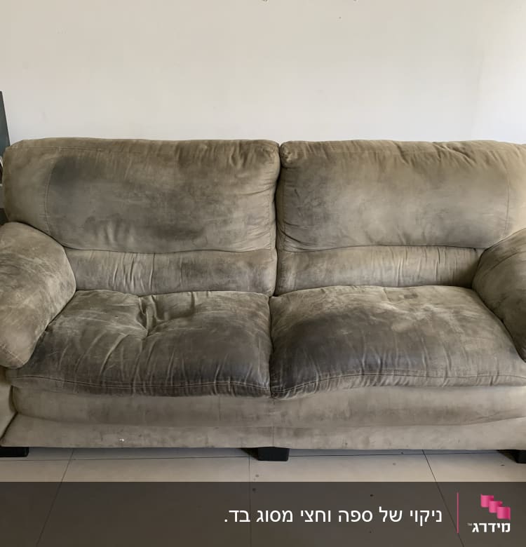 ספה מלוכלכת עם כתמים כהים על הריפוד